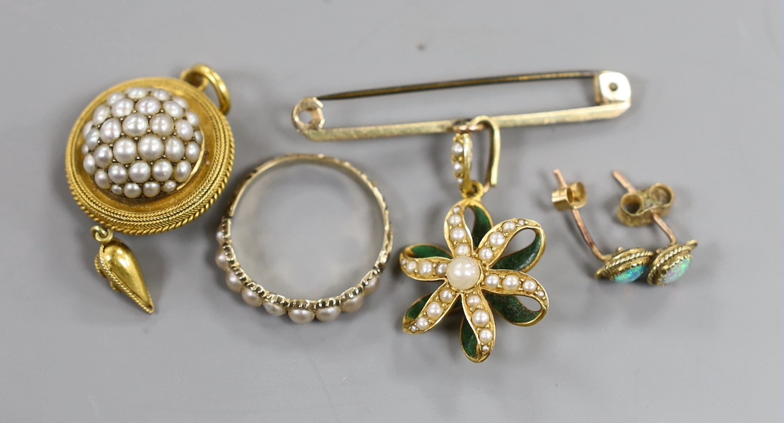 A Victorian yellow metal and seed pearl set drop mourning pendant, with plaited hair verso, 32mm, a yellow metal and split pearl set half hoop ring, a 15ct and seed pearl set flower head pendant on a 9ct bar suspension b